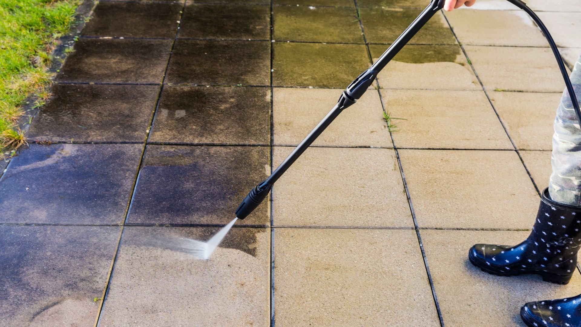 Pressure washer cleaning patio tiles with water spray